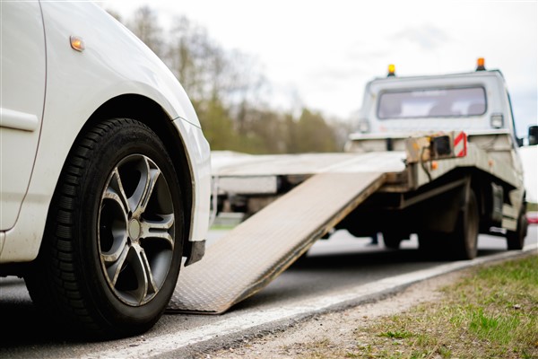 Image of a car moving onto a tow truck